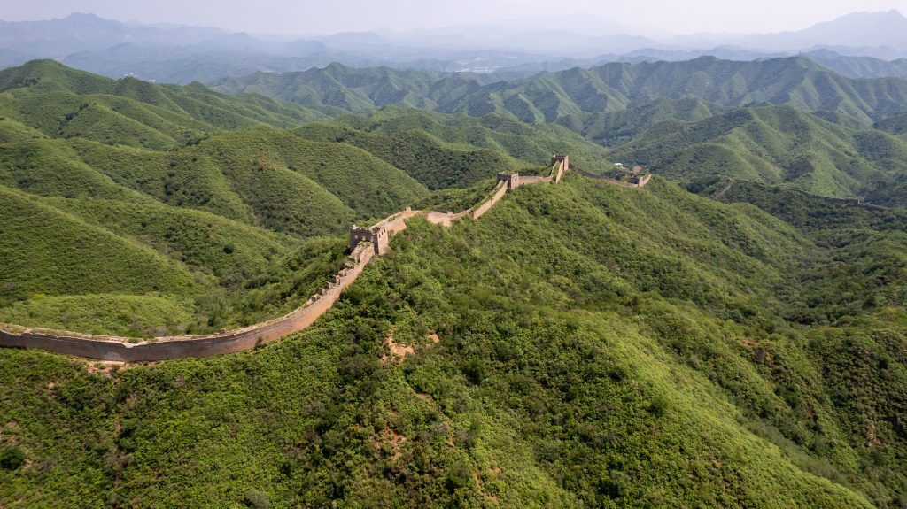 Drohnenaufnahme der wilden Panlongshan Chinesischen Mauer umgeben von Wäldern. 