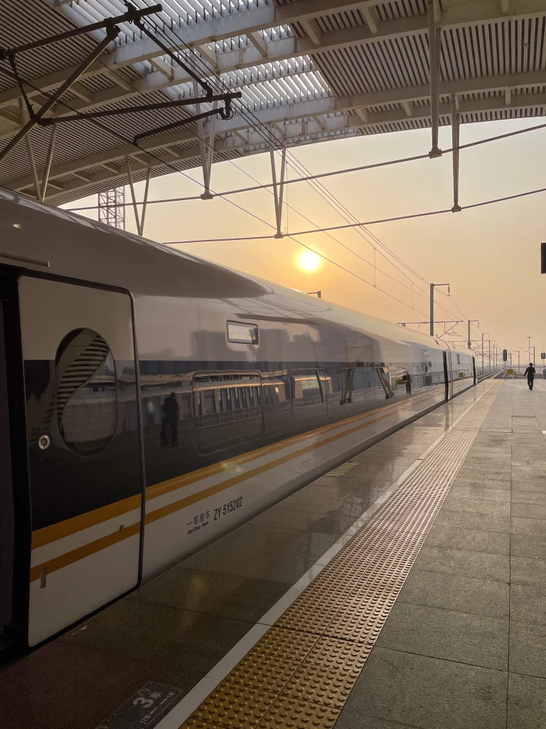 Zug in China im Bahnhof mit Sonnenuntergang im Hintergrund.