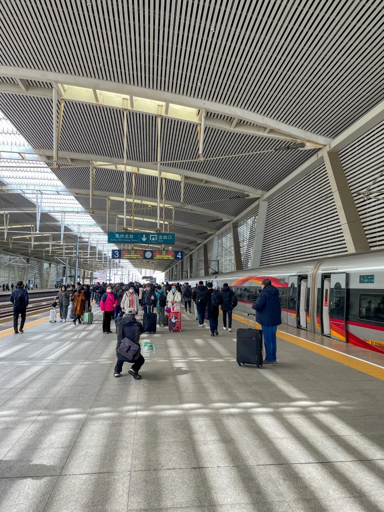 Zug in China im Bahnhof mit aussteigenden Passagieren.