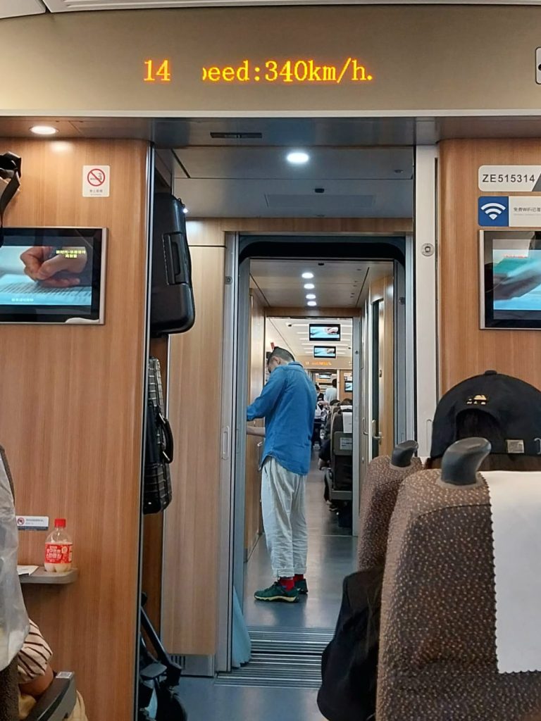 Zugfahren in China mit Geschwindigkeitsanzeige von 340km/h.