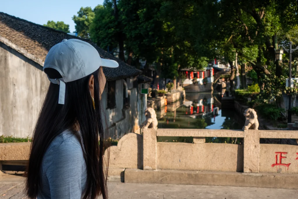 Frau auf einer Brücke über einen Kanal in der Wasserstadt Luzhi.