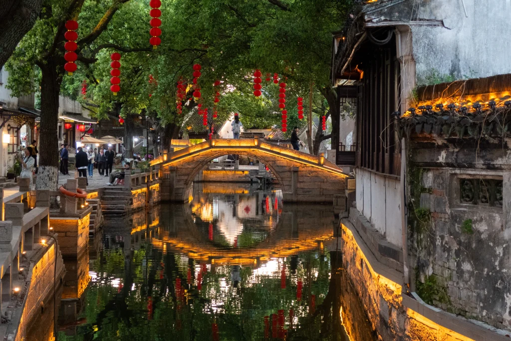 An illuminated historic bridge in the water town of Tongli, Suzhou. 