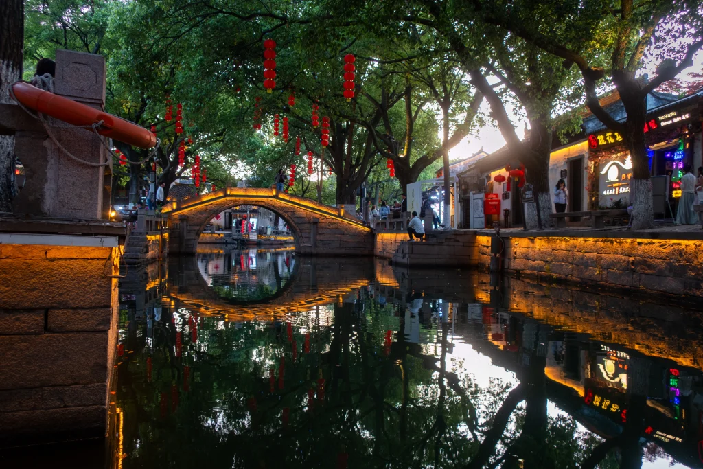 An illuminated historic bridge in the water town of Tongli, Suzhou. 